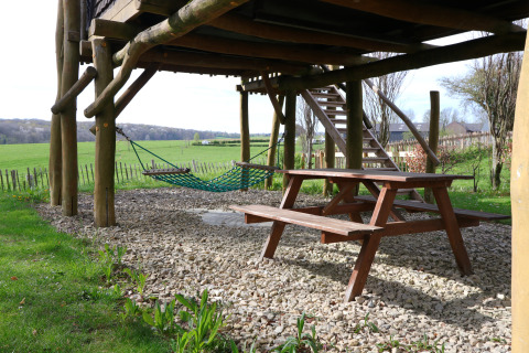 Udsigt under et træhus ved Treelodge, Gulperberg, Holland, med picnicbord og hængekøje.