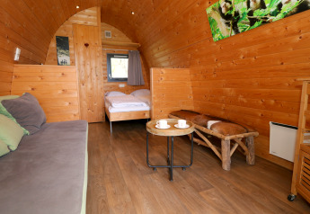 Intérieur chaleureux en bois d’une cabane Treelodge à Gulperberg, Pays-Bas, avec mobilier rustique.