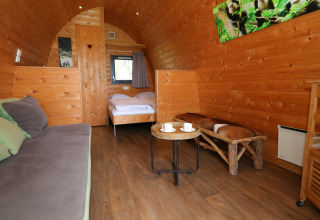 Hyggeligt interiør i en træhytte ved Treelodge, Gulperberg, Holland, med trævægge og naturlig indretning.