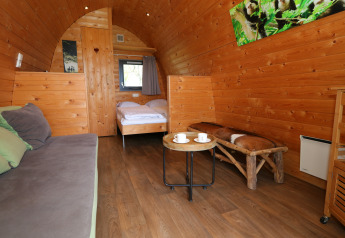 Acogedor interior de madera en casa árbol Treelodge, Gulperberg, Países Bajos, con decoración rústica.
