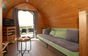 Gezellig interieur van een boomhut bij Treelodge, Gulperberg, met zetel, tafel en uitzicht.