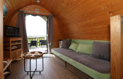 Knus interieur van een boomhut bij Treelodge, Gulperberg, met bank, tafel en uitzicht.