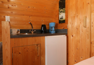 Kleine keukenhoek in een boomhut bij Treelodge, Gulperberg, Nederland, met koffiemachine en spoelbak.