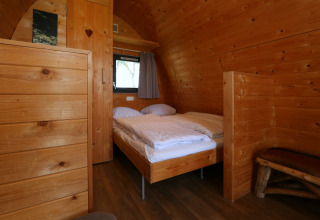Houten interieur van een Treelodge boomhut in Gulperberg, Nederland, met tweepersoonsbed.