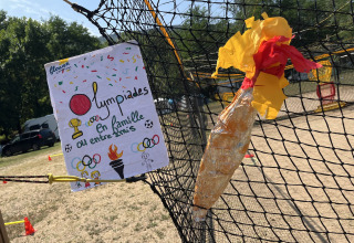 Selbstgebastelte Olympische Fackel und Poster für Familienolympiade bei Flower Camping Le Pont du Tarn.