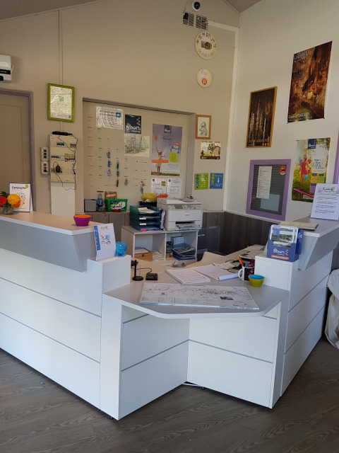 Receptionen på Flower Camping Le Pont du Tarn i Occitanien, Frankrig, med informationsmateriale og skranke.