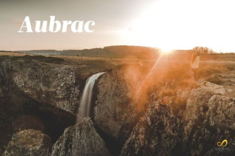 Smuk solnedgang over et vandfald og klipper i Aubrac, nær Flower Camping Le Pont du Tarn, Occitanie, Frankrig.
