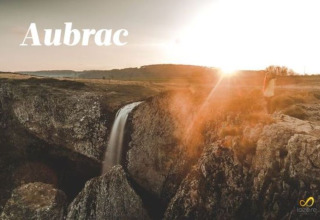 Smuk solnedgang over et vandfald og klipper i Aubrac, nær Flower Camping Le Pont du Tarn, Occitanie, Frankrig.