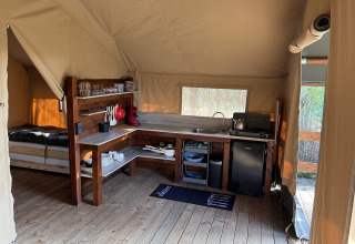 Indvendig af en safaritelt med fuldt udstyret køkken og soveområde på Camping 'de Val' i Holland.