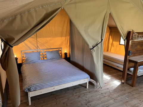Interno di una tenda safari con letto matrimoniale e singolo al Camping 'de Val' nei Paesi Bassi.