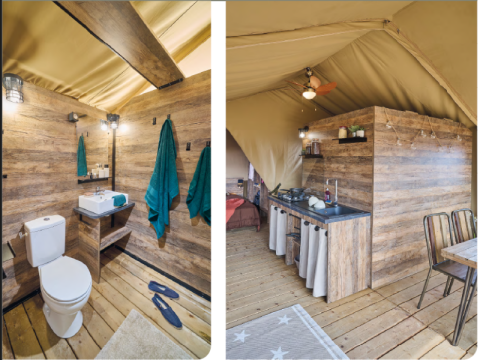 Innenraum eines Safari-Zeltes der Kenya Lodge bei Flower Camping Le Pont du Tarn, Frankreich, mit Bad und Küche.