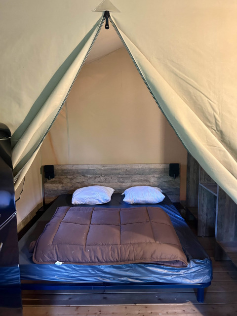 Safari-Zelt mit Doppelbett und Holzboden in der Kenya Lodge, Flower Camping Le Pont du Tarn, Frankreich.