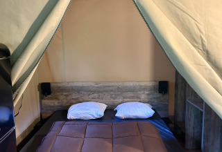 Safari-Zelt mit Doppelbett und Holzboden in der Kenya Lodge, Flower Camping Le Pont du Tarn, Frankreich.