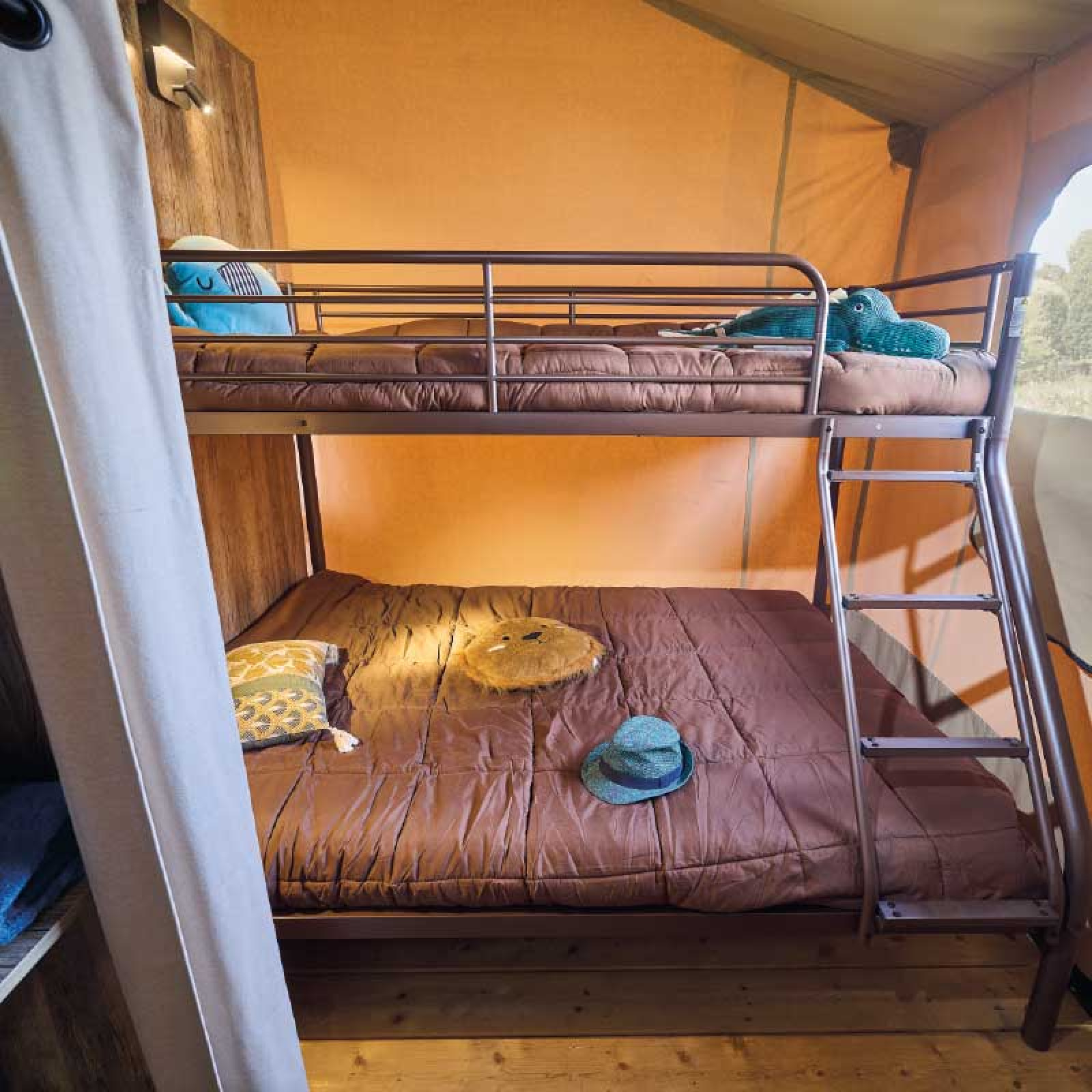 Stapelbed met bruin beddengoed en leuke kussens in een safaritent bij Kenya Lodge, Flower Camping Le Pont du Tarn, Frankrijk.