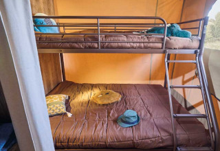 Etagenbett mit brauner Bettwäsche in einem Safari-Zelt der Kenya Lodge bei Flower Camping Le Pont du Tarn, Frankreich.