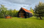 Forest villa De Bosburcht avec sauna, maison moderne entourée de verdure et grand jardin herbeux.