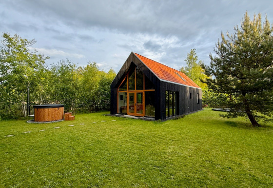 Forest villa De Bosburcht con sauna, moderno chalet circondato dal verde e ampio prato erboso.