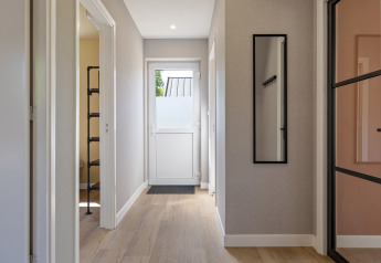 Flur im Forest villa «Heidehaas» in De Kremmer, Niederlande, mit hellem Holzfußboden und modernem Design.