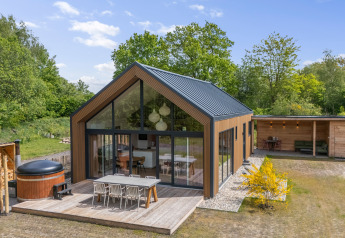 Moderne Ferienlodge aus Holz mit Terrasse bei De Kremmer, Forest villa «Heidehaas» in den Niederlanden.