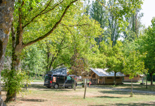 Tente safari Ponza et van campeur sous des arbres verts au Onlycamp Camping de l'Argenté en France, ambiance naturelle paisible.
