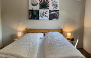 Schlafzimmer im Private Lodge im Bungalow Park Het Verscholen Dorp mit zwei Einzeldecken und Wandkunst.