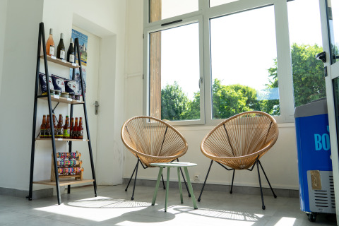 Espace détente moderne, lumineux, avec fauteuils, snacks et boissons au Onlycamp Camping La Gâtine.