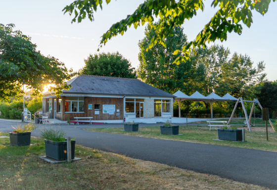 Vue ensoleillée de Onlycamp Camping La Gâtine avec aire de jeux et verdure en Centre-Val de Loire, France.