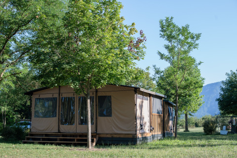Safari-tent Galli Tiny-house bij Onlycamp Camping Les Tuillères in Frankrijk, midden in het groen en bomen.