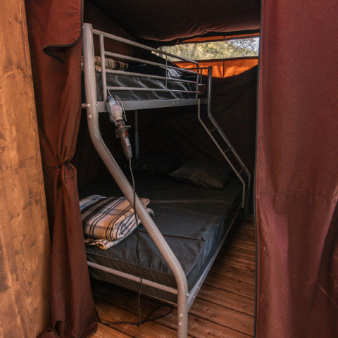 Innenansicht des Chalet Galli bei Onlycamp Camping de Besançon mit Etagenbett und gemütlicher Atmosphäre.