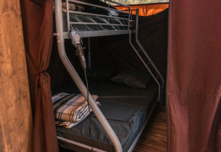 Innenansicht des Chalet Galli bei Onlycamp Camping de Besançon mit Etagenbett und gemütlicher Atmosphäre.