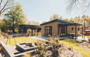 Moderno lodge Loevestein Deluxe en Veluwe park de Bosgraaf, Países Bajos, con terraza y jardín verde.