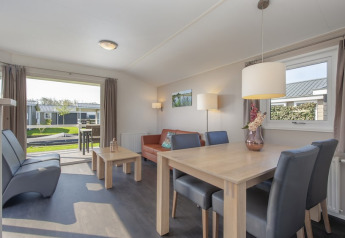 Salon lumineux du lodge Meerkoet 4 à Giethoorn, Pays-Bas, avec mobilier moderne et vue sur terrasse.