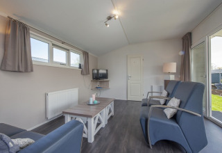 Modernes Wohnzimmer in der Stern 6 Lodge in Giethoorn, Niederlande, mit blauen Sesseln.