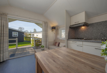 Vue intérieure de Tiny House 2 à Giethoorn, Pays-Bas, avec cuisine et espace extérieur verdoyant.
