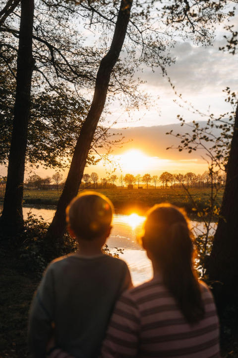 Twee kinderen kijken naar de zonsondergang bij Glamphuys Ultra safaritent op Landgoed Ruysbos, Nederland.