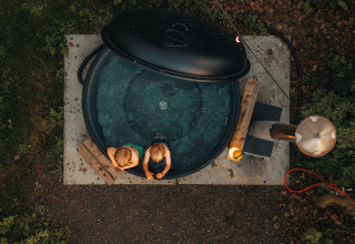 Luchtfoto van twee kinderen in een ronde hottub bij Glamphuys Ultra safaritent op Ruysbos domein, Nederland.