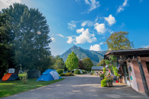 Tenten in een vakantiepark met uitzicht op bergen en blauwe lucht bij Onlycamp Camping Les Thézières, Frankrijk.