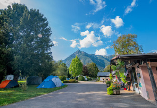 Tenten in een vakantiepark met uitzicht op bergen en blauwe lucht bij Onlycamp Camping Les Thézières, Frankrijk.