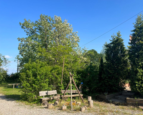 Camping Vauban in Grand Est, Frankrijk, met houten bankjes, kampvuurplek en veel groen in de omgeving.
