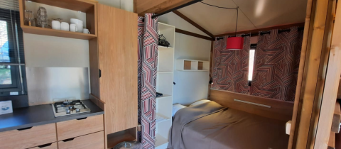 Cocina y zona de dormitorio en la tienda safari Galli Tiny-house en Camping Vauban, Francia, ambiente moderno.