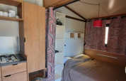 Küche und Schlafbereich im Galli Tiny-house Safari-Zelt auf Camping Vauban in Frankreich, modern gestaltet.