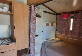 Cocina y zona de dormitorio en la tienda safari Galli Tiny-house en Camping Vauban, Francia, ambiente moderno.
