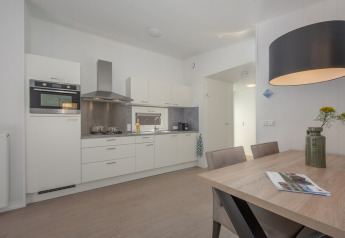 Cucina e zona pranzo moderne e luminose in una tiny house al Lodge Wellness 4, Bospark 't Wolfsven, Paesi Bassi.