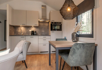 Modern and cozy tiny house kitchen and dining area at Tiny House 2, Bospark 't Wolfsven, Netherlands.