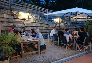 Gasten genieten van een avond buiten bij vakantiepark Domaine Papillon in Occitanië, Frankrijk.