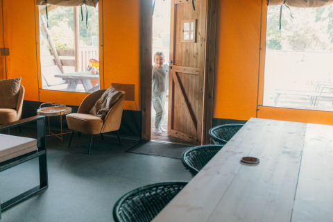 Intérieur d'une tente safari de luxe avec porte ouverte et enfant, Holiday park Sallandshoeve, Pays-Bas.