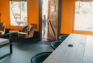 Intérieur d'une tente safari de luxe avec porte ouverte et enfant, Holiday park Sallandshoeve, Pays-Bas.