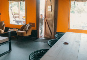 Intérieur d'une tente safari de luxe avec porte ouverte et enfant, Holiday park Sallandshoeve, Pays-Bas.