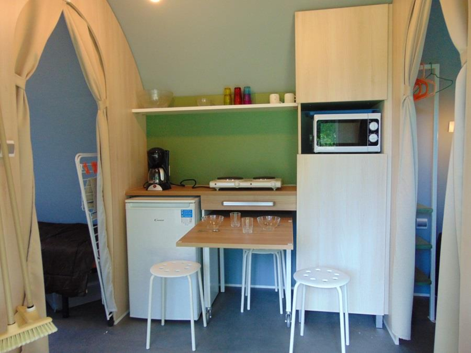Keukenhoek in een Coco Sweet safaritent op Flower Camping Le Pont du Tarn in Frankrijk met tafel en krukken.
