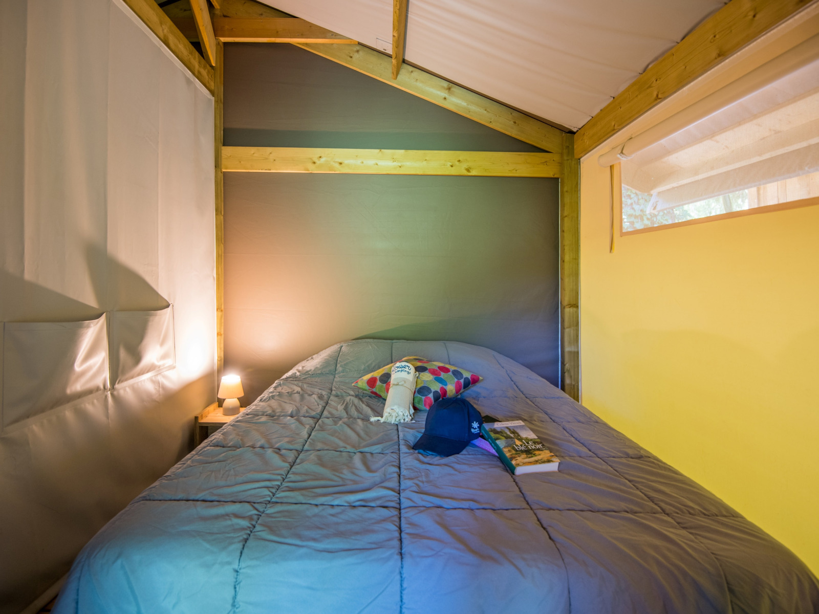 Knusse slaapkameropstelling in een Freeflower Comfort safaritent bij Flower Camping Le Pont du Tarn, Frankrijk.
